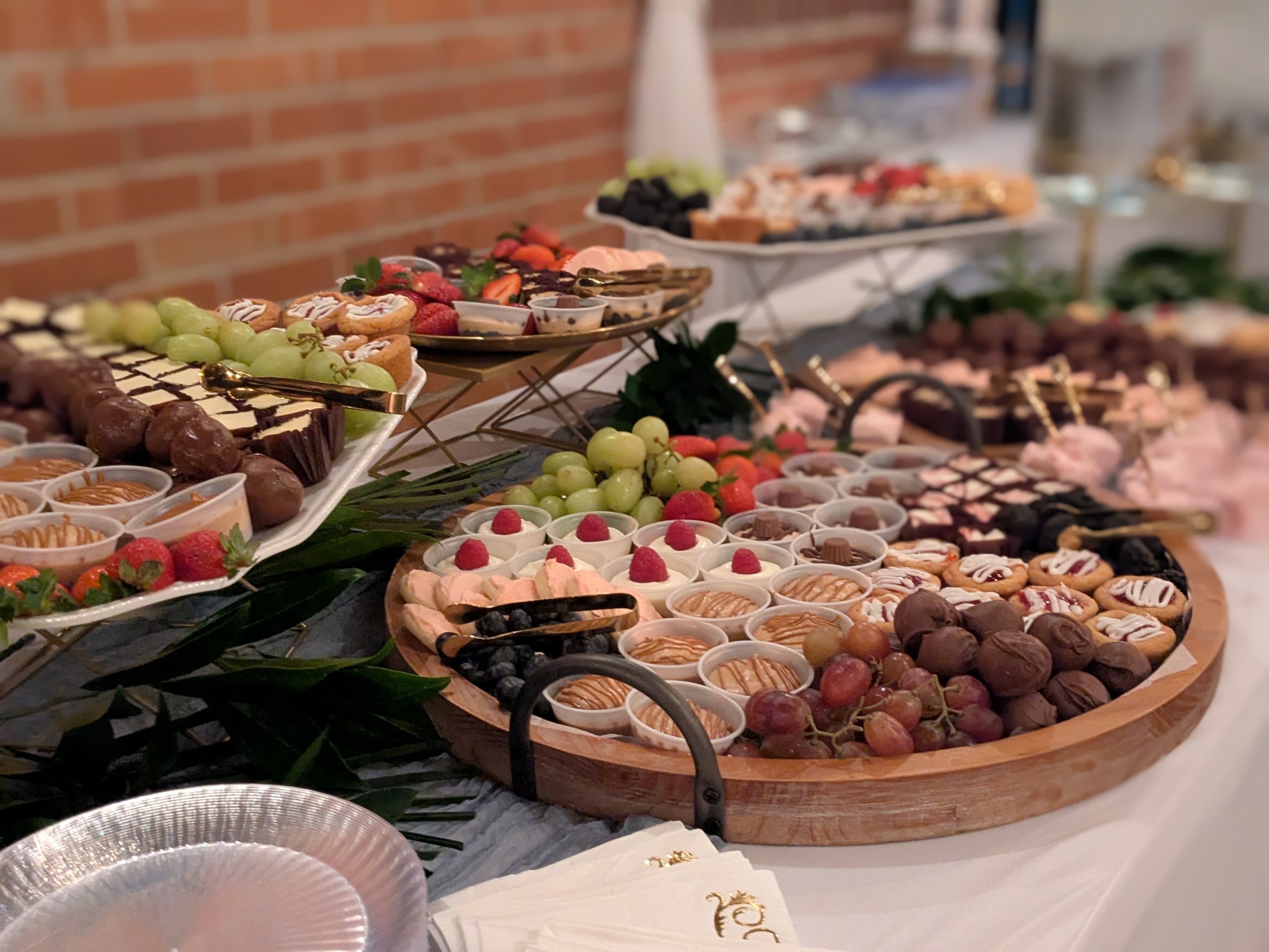 Dessert buffet, small cheesecakes, cookies, fresh fruit, brownies, dessert cups, raspberry parfait